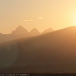 Photograph by CallyAnn hamilton of the Tetons illuminated by an orange sunrise.
